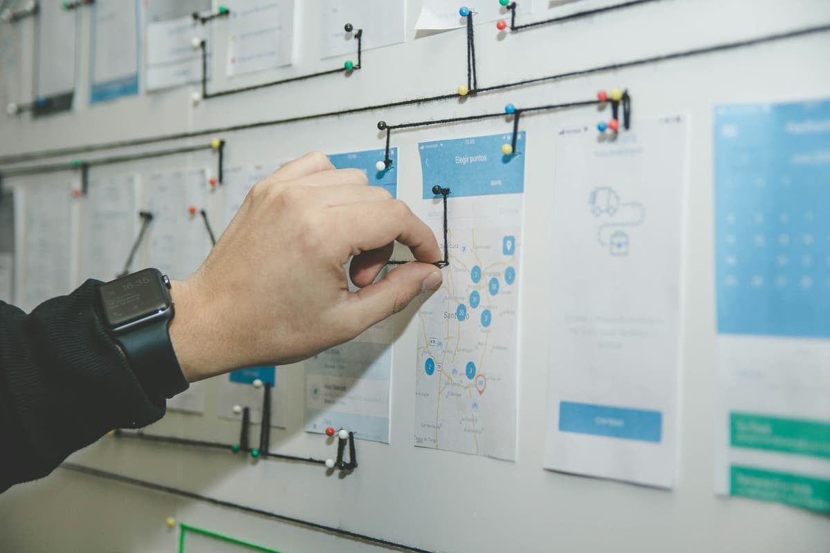Person organizing blue and white papers on planning board